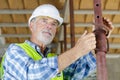 senior man looking through construction pipes