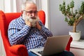 Senior man looking at laptop and boring at home Royalty Free Stock Photo
