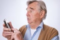 Senior man looking surprised and using his mobilphone Royalty Free Stock Photo