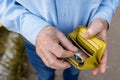 Senior man looks in his purse with Euro banknotes. A wallet with the last money in the hands of an elderly man. A Royalty Free Stock Photo