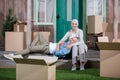 Senior man lying on knees of smiling wife sitting on porch of new house