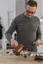 Senior man makes fresh Turkish coffee in turk and fresh healthy breakfast with vegetables Royalty Free Stock Photo