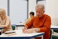 Senior man making notes at training