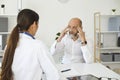 Senior male patient with a headache at a doctor appointment in a white office of a medical clinic. Royalty Free Stock Photo