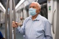 Senior man in mask inside subway car Royalty Free Stock Photo