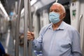 Senior man in mask inside subway car Royalty Free Stock Photo
