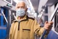 Senior man in mask inside subway car Royalty Free Stock Photo