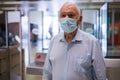 Senior man in mask beside turnstile in subway station