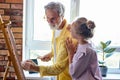 Senior man, grandfather and his granddaughter drawing, painting together Royalty Free Stock Photo