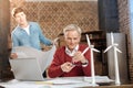 Senior man measuring distance on protractor with compass