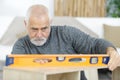 senior man measuring level furniture Royalty Free Stock Photo