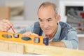 senior man measuring wall with construction level Royalty Free Stock Photo