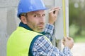 senior man measuring wall with construction level Royalty Free Stock Photo