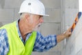 senior man measuring wall with construction level Royalty Free Stock Photo