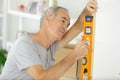 senior man measuring wall with level Royalty Free Stock Photo