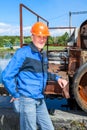 Senior man mechanist stands near sewage treatment plant