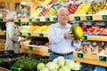 Senior man with melon in greengrocer Royalty Free Stock Photo