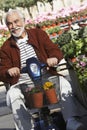 Senior Man On Motor Scooter At Garden