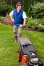 Senior man mowing lawn.