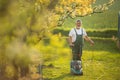 Senior man mowing the lawn in his garden Royalty Free Stock Photo