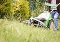 Senior man mowing the lawn with a lawnmower Royalty Free Stock Photo