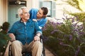 Senior man, nurse and wheelchair in elderly care, talking or healthcare support at nursing home. Happy mature male and Royalty Free Stock Photo