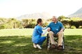 Senior man, nurse and wheelchair in nature for healthcare support, life insurance or garden at nursing home. Happy Royalty Free Stock Photo