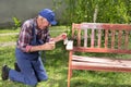 Old man painting bench in garden Royalty Free Stock Photo