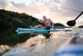 Senior man paddleboarding on lake in summer. Copy space.