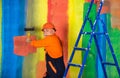 Senior man painter use roller on ladder. painting the wall colorful. professional painter in working clothes. worker Royalty Free Stock Photo