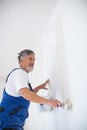 Senior man painting a room of rental appartment Royalty Free Stock Photo