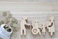 Senior man and people on wheelchairs with pregnant woman with stack of coins money on wooden background, Save money for