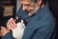 Senior man petting his cat on a sofa