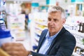 Senior man, pharmacy or customer searching for retail healthcare pills, medicine in drugstore. Looking, businessman or Royalty Free Stock Photo