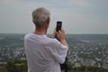 Senior man photographs on the phone a view of the city. Pyatigorsk, Russia