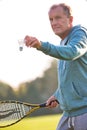 Senior man playing badminton with tennis racket in park Royalty Free Stock Photo