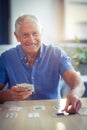 Senior man playing cards in living room Royalty Free Stock Photo