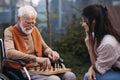 Senior man playing chess outdoors with his daughter. Royalty Free Stock Photo