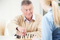 Senior Man Playing Chess With Teenage Granddaughter