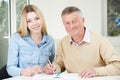 Senior Man Playing Completing Sudoku Number Puzzle With Teenage