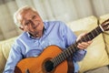 Senior man playing guitar at home Royalty Free Stock Photo