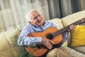 Senior man playing guitar at home Royalty Free Stock Photo