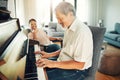 Senior man playing piano for music in living room with wife for bonding, entertainment or having fun. Happy, smile and Royalty Free Stock Photo