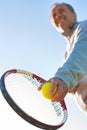 Senior man playing tennis against clear sky on sunny day Royalty Free Stock Photo