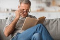 Senior Man With Poor Eyesight Reading Book Above Eyeglasses Indoor Royalty Free Stock Photo