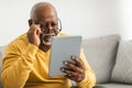 Senior Man With Poor Eyesight Using Tablet Squinting Eyes Indoor Royalty Free Stock Photo