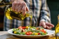 senior man pouring olive oil on a mediterraneanstyle salad Royalty Free Stock Photo