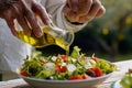 senior man pouring olive oil on a mediterraneanstyle salad Royalty Free Stock Photo