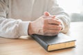 Senior man praying, reading  an old Bible in his hands Royalty Free Stock Photo