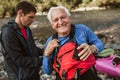 Senior man preparing for kayak tour on a mountain river